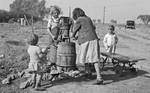 Bambini alla pompa dell'acqua, un'istantanea di Dorothea Lange che cattura la vita quotidiana.