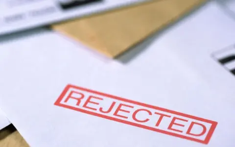 Czerwony stempel "REJECTED" na dokumencie, który mógł być wnioskiem o pozwolenie na broń.