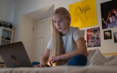 Dziewczyna szuka w internecie informacji, gdzie można pracować w wieku 16 lat.