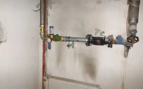 Instalacja wodna z widocznym elementem pokazującym, jak działa reduktor ciśnienia wody, z manometrem i zaworem.