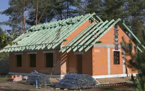 Budowa domu z cegły, widoczna konstrukcja dachu. Stosowana metoda gospodarcza pozwala na oszczędności.