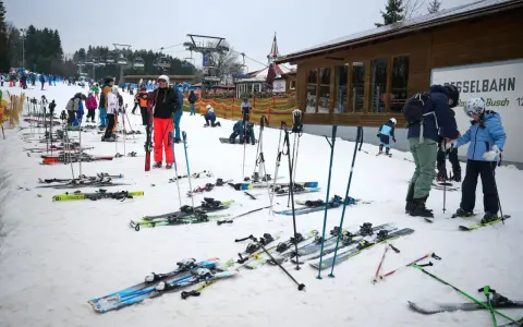 Skifahrer warten auf die Gondelbahn. Entdecke die **Winterberg Geheimtipps** für deinen nächsten Skiurlaub!