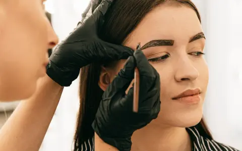 Application de henné sur les sourcils pour un regard intense.