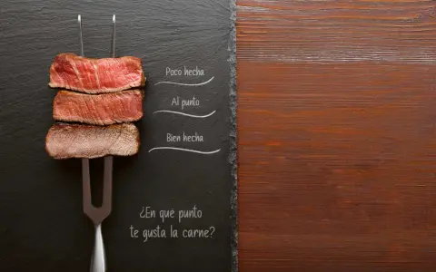 Filete de ternera en un tenedor, mostrando diferentes puntos de cocción: poco hecha, al punto y bien hecha.