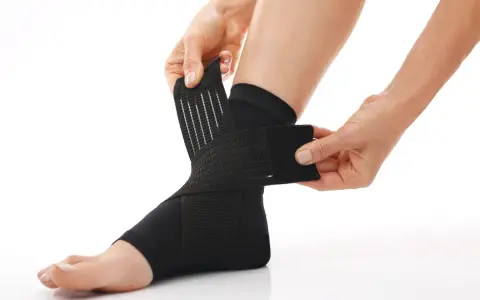 Hands adjust a black compression ankle brace, demonstrating how compression therapy works for support and recovery.