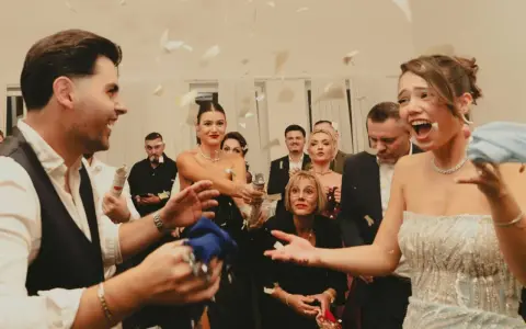 Wesele w pełni! Goście sypią konfetti, a młoda para cieszy się chwilą. Czy osoba towarzysząca daje prezent na wesele?