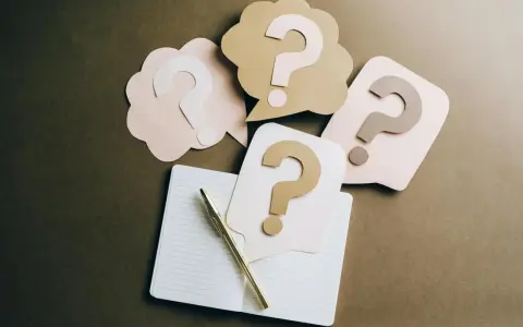 Penne e quaderno aperto, circondati da fumetti con punti interrogativi. Un invito a fare domande, con la promessa di patrocinio gratuito.