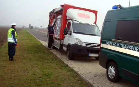 Kontrola drogowa: funkcjonariusz w kamizelce odblaskowej kieruje ruchem, obok biała ciężarówka z ładunkiem. Czy kierowca ma prawo jazdy kat b do 7,5 tony?