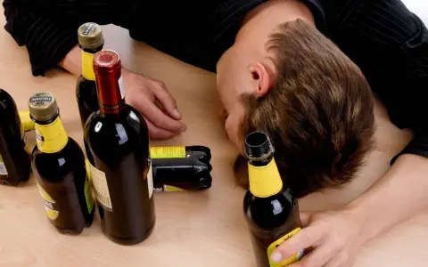 Ein Mann liegt bewusstlos auf einem Tisch, umgeben von leeren Flaschen. Der Gedanke, dass **Whisky gesund** sein könnte, ist hier wohl fehl am Platz.