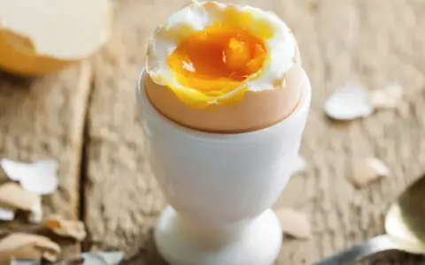 Jajko na miękko w kieliszku, z płynnym żółtkiem. Czy jajka podwyższają cholesterol? Pytanie, które nurtuje wielu.