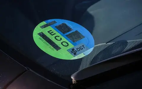 Pegatina ECO en parabrisas, indicando que es uno de los coches sin etiqueta que cumplen normativas ambientales.