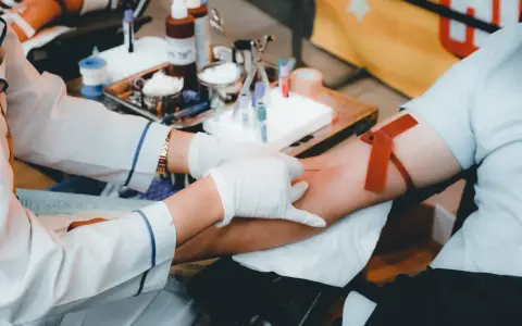 Po oddaniu krwi, zasłużona kawa. Personel medyczny pobiera krew od dawcy, przygotowując wszystko do dalszych badań.