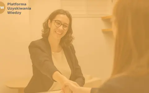 Uśmiechnięta kobieta po 40. zawiera umowę o pracę, symbolizując udaną zmianę pracy.