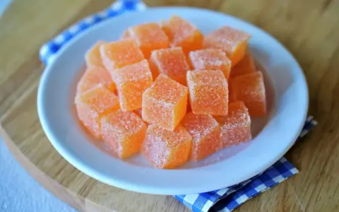 Dulces cubos de naranja cubiertos de azúcar, perfectos para aprender como hacer chuches caseras.