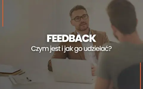 Dwóch mężczyzn przy biurku, jeden z nich udziela feedbacku. Czym jest feedback i jak go udzielać?