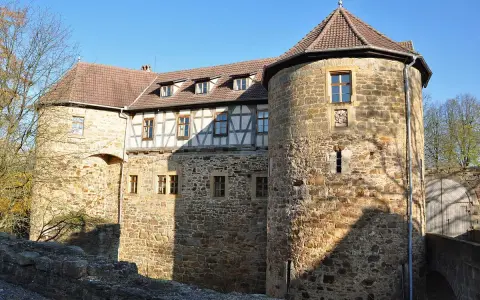Die Burg von Bibra, ein historisches Gemäuer mit Rundturm und Fachwerk, strahlt im Sonnenlicht.