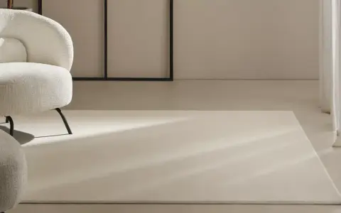 Un espacio moderno con sillones blancos y alfombras de lana a medida, bañadas por la luz natural.