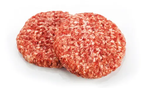 Dwa surowe kotlety mielone na burgery na białym tle.