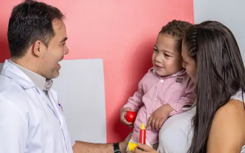 Médico habla con madre y niño, buscando entender los problemas de concentración del pequeño.