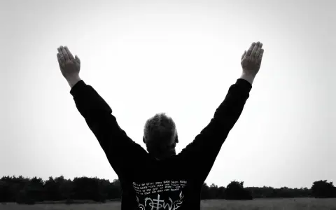 Mann mit erhobenen Armen im Freien, inspiriert von Psalm 92.