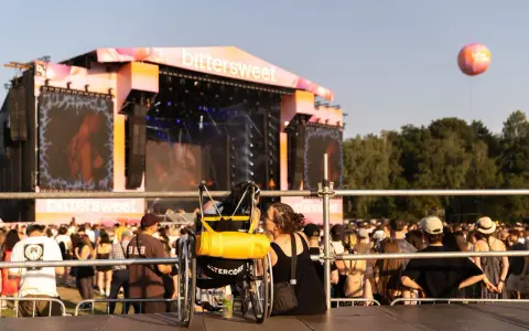 Dwie osoby, jedna na wózku, dzielą intymną chwilę na festiwalu bittersweet.
