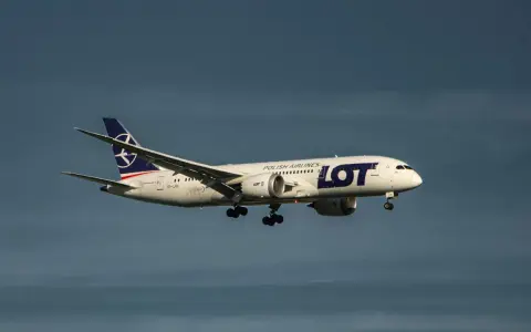 Samolot LOT Polish Airlines z bagażem podręcznym w locie, zbliżający się do lądowania.