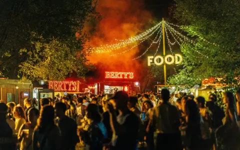 Noche de fiesta con luces de neón "Bertys" y "Food", gente disfrutando, ideal para canciones para un día ewan.