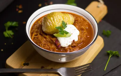 Un plat réconfortant de cuisine des terroirs aujourd'hui : choucroute garnie avec une pomme de terre Hasselback et une touche de crème.