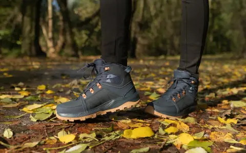 Jesienne buty trekkingowe na tle liści. Idealne, by dowiedzieć się, jak się ubrać w góry jesienią.