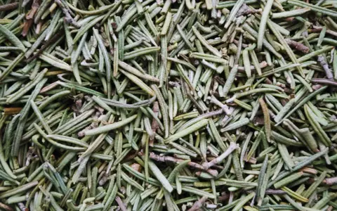 Gros plan sur des aiguilles de romarin séchées, idéales pour l'huile essentielle romarin mémoire posologie.