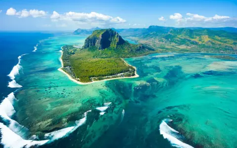 Widok z lotu ptaka na Mauritius: turkusowa laguna, góra Le Morne Brabant i białe fale rozbijające się o rafę. Idealne miejsce na loty na Mauritius.
