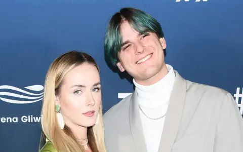 Tribbs, kto to? Młody influencer z zielonymi włosami i jego dziewczyna na ściance.