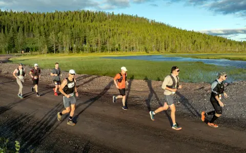 Löpare i en terrängtävling nära en sjö och skog. Bra vasaloppet tips för löpare: träna uthållighet och terränglöpning.
