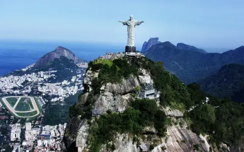 Majestatyczny pomnik Rio de Janeiro Jezus góruje nad miastem i oceanem, otoczony bujną zielenią i skalistymi szczytami.