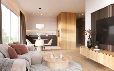 Przytulny salon z sofą, stolikiem kawowym i aneksem kuchennym w stylu japandi. Drewniane elementy i neutralne kolory tworzą harmonijną przestrzeń.