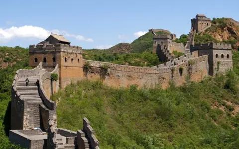 Die Chinesische Mauer, eine beeindruckende yajuj majuj location, schlängelt sich über grüne Hügel.