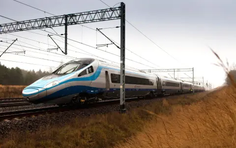 Nowoczesny Pendolino pędzi po torach, symbolizując rosnącą prędkość pociągów w Polsce.