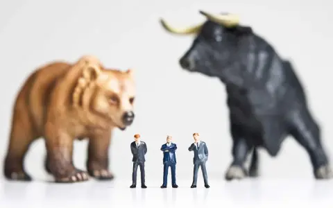 Miniature businessmen stand between a bear and a bull, symbolizing market volatility and the quest for art investment returns.
