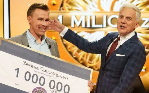 Bartosz Radziejewski, który wygrał milion w Milionerach, odbiera czek z nagrodą od Huberta Urbańskiego.