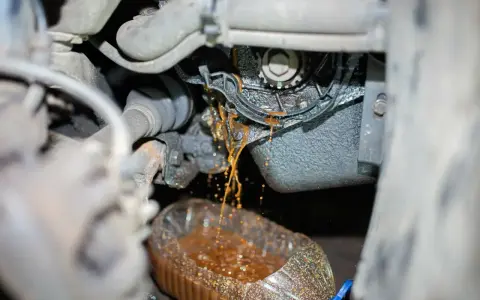 Flüssigkeit tropft aus einer undichten Wasserpumpe in einen Behälter.