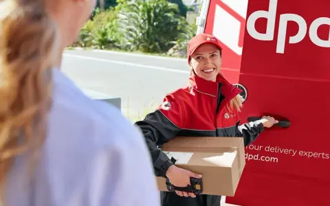 Kurierka DPD z paczką, obok czerwonego vana. Na paczce widoczny numer listu przewozowego przykład.