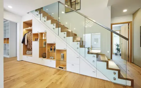 Schickes **schmales Reihenhaus einrichten**: Stauraumwunder unter der Treppe mit Garderobe, Regalen und Schubladen. Moderne Glasbrüstung.