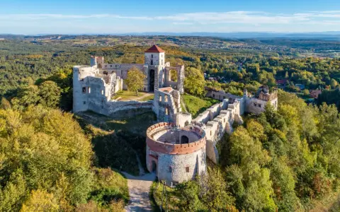 Ruiny zamku w Krzeszowicach, majestatycznie wznoszące się na wzgórzu, otoczone jesiennym lasem.