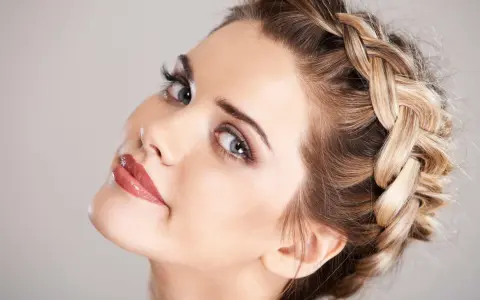 Modella con treccia a corona, ispirazione per 10 acconciature facili e veloci. Labbra lucide e sguardo intenso.