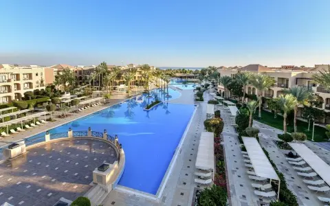 Luksusowy resort Jaz Aquamarine z basenami o turkusowej wodzie, palmami i budynkami hotelowymi.