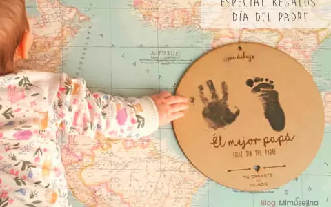 Manualidad Día del Padre 2 años: huella de mano y pie de bebé en un círculo de cartón sobre un mapa.