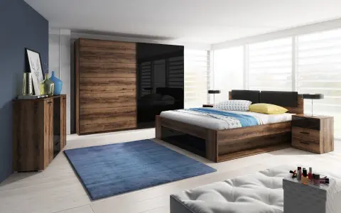 Dormitorio con muebles oscuros de madera y cristal negro. Pared azul oscuro, alfombra azul y cama con ropa de cama blanca y azul.