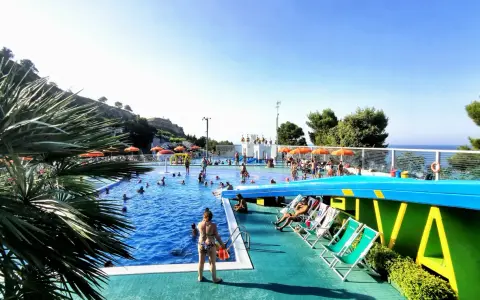 Sole, piscina e divertimento al camping Riva Verde Marche. Famiglie e bambini si godono l'acqua cristallina e il relax sotto gli ombrelloni.