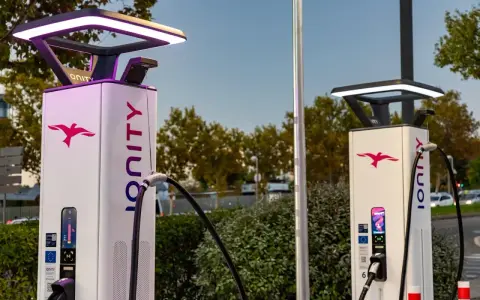 Dos modernas gasolineras eléctricas con el logo de Ionity y luces LED.