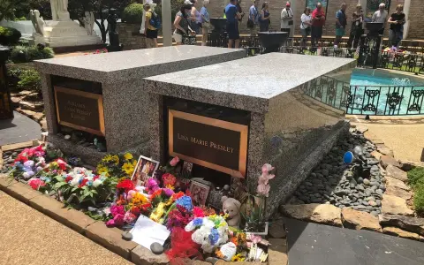 Gräber von Lisa Marie und Benjamin Keough, umgeben von Blumen. Viele Besucher ehren das Erbe von Elvis Presley.